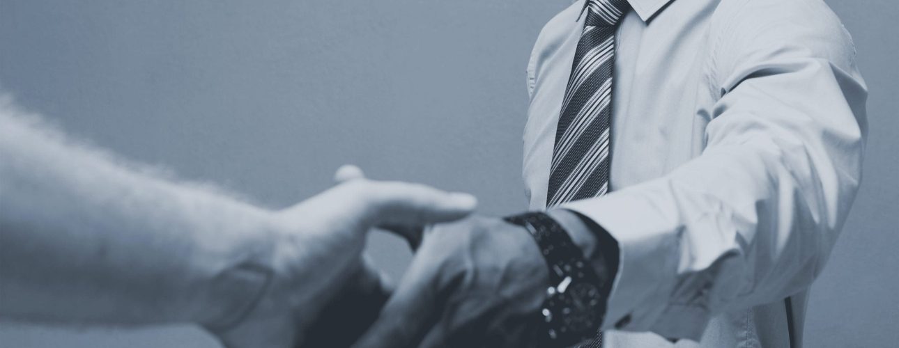 Business concept - Close-up of two confident business people shaking hands during a meeting